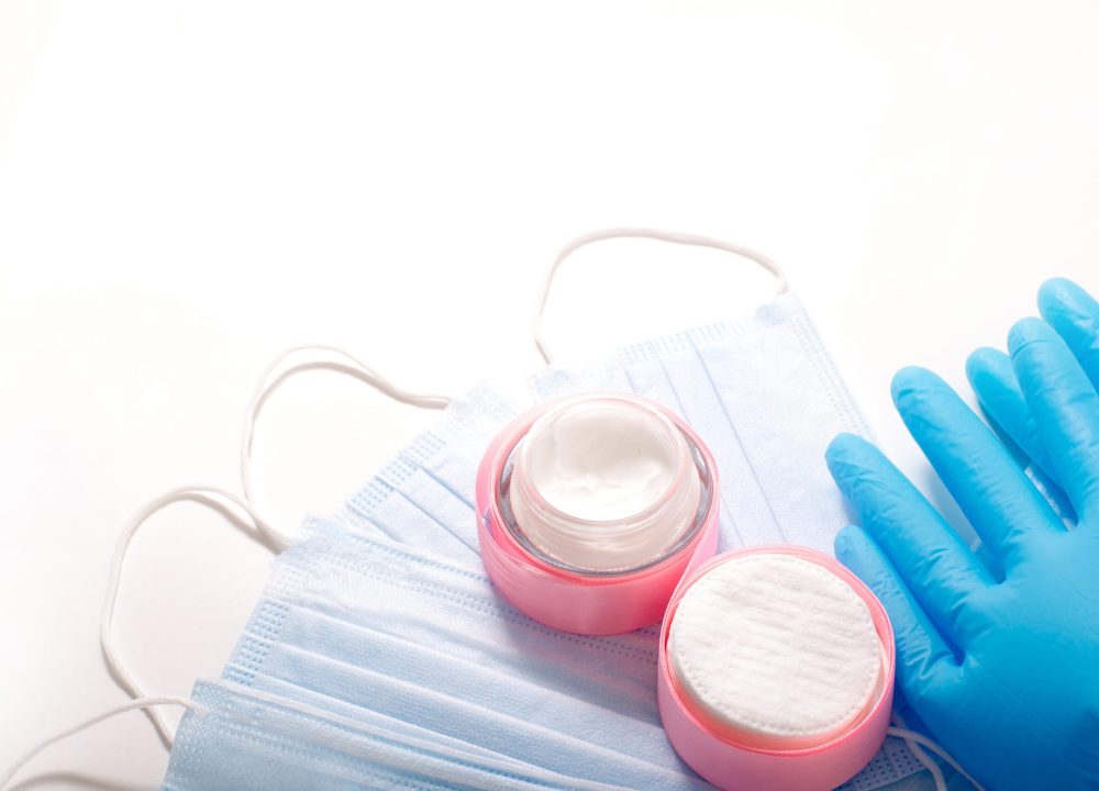 Beauty accessories on white background. Blue gloves, masks, and cream. High-quality photo